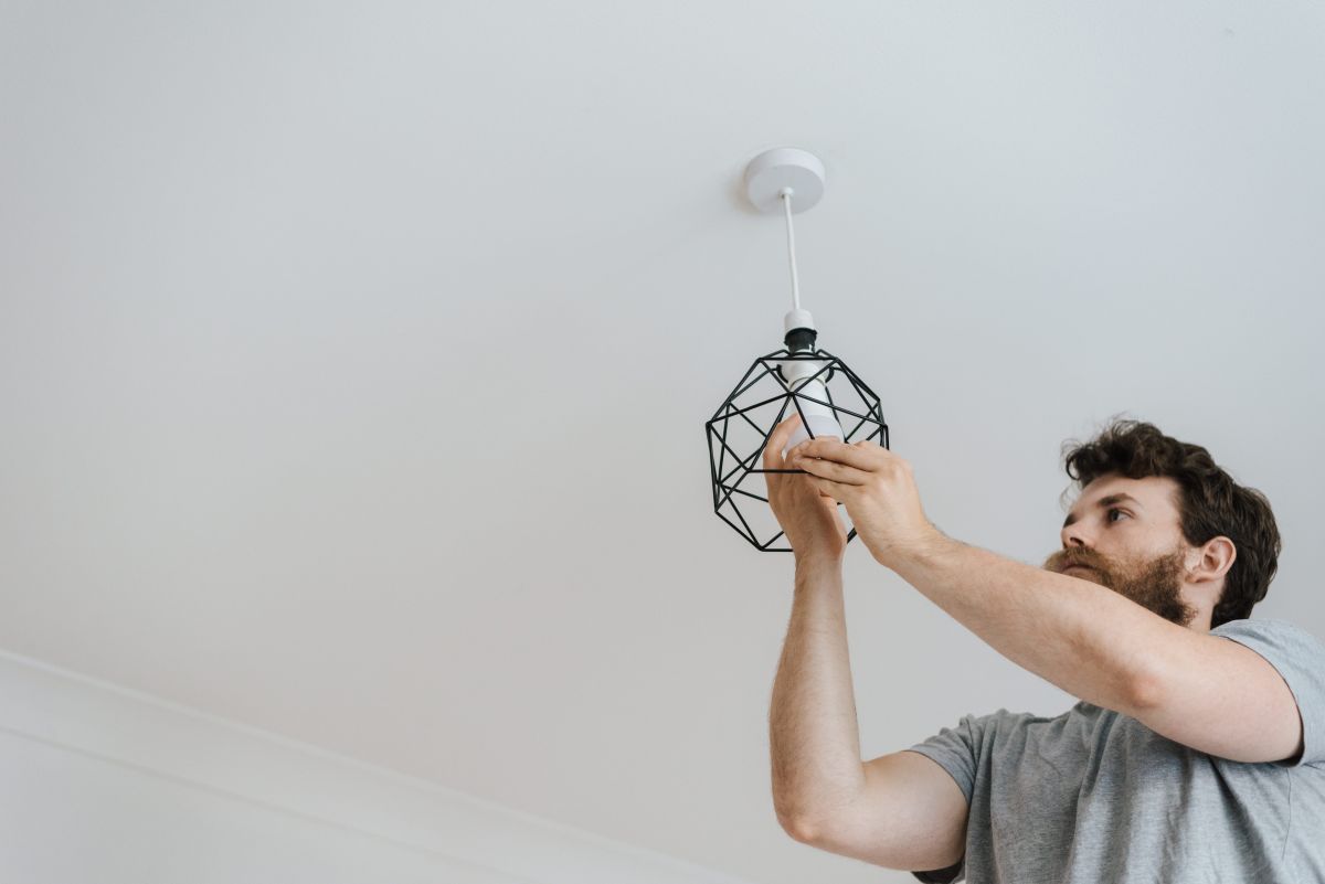 Master electrician installing a ceiling light in Sunrise 