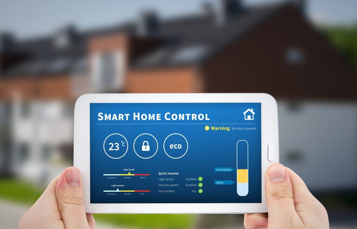 Hands Holding Tablet in Front of House for Smart Home Installation Services in Sunrise