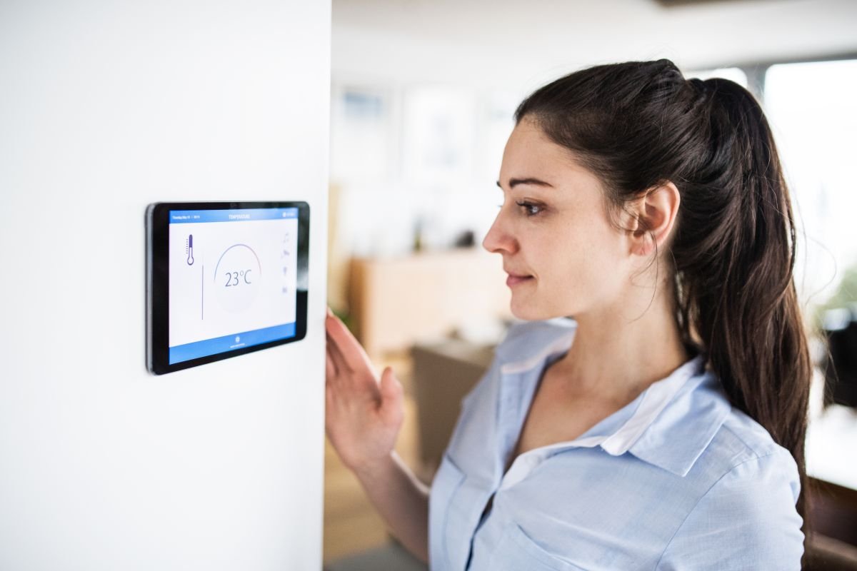 Woman Looking at Wall Thermostat with Smart Home Installation Services in Weston